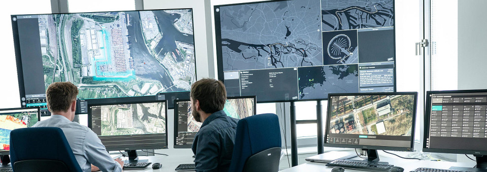 Drone pilots sitting in front of monitors