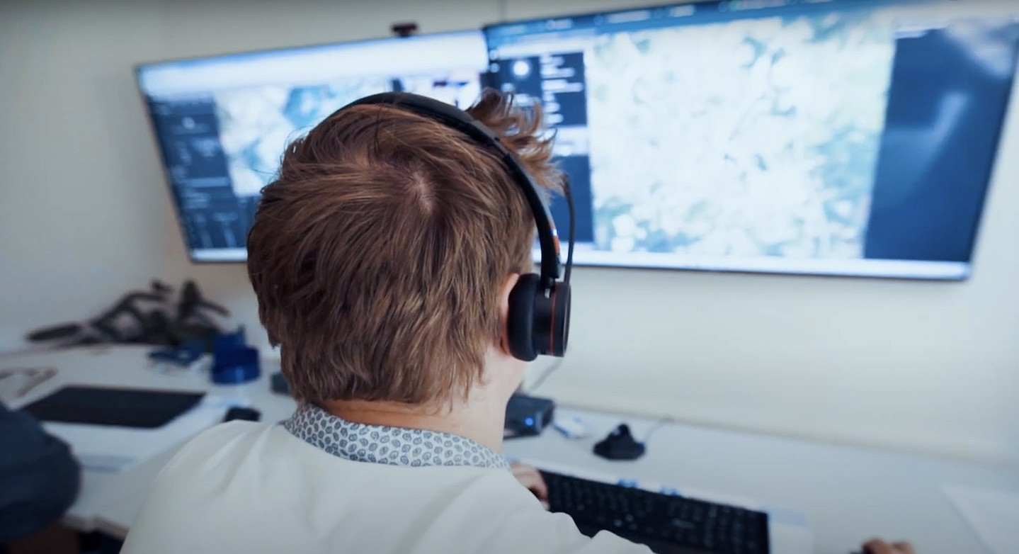 Person with headset in front of drone control screen