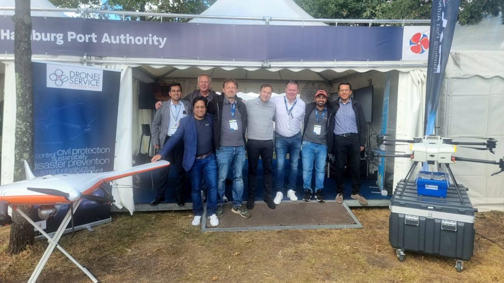Group of 8 presenting drone at an outdoor trade fair